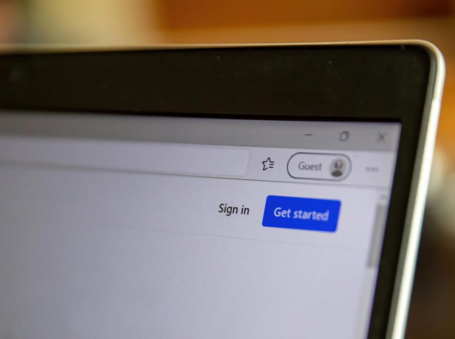 8CLICKS | A close-up view of a laptop screen showing the top section of a web browser. It displays options to "Sign in" and "Get started" along with a "Guest" profile icon.