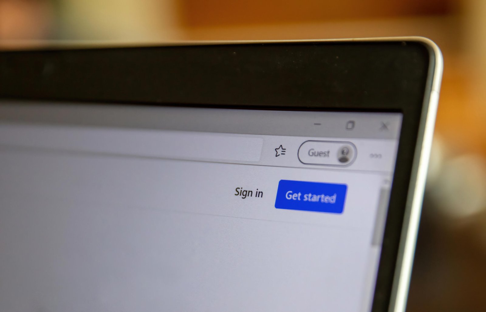 8CLICKS | A close-up view of a laptop screen showing the top section of a web browser. It displays options to "Sign in" and "Get started" along with a "Guest" profile icon.