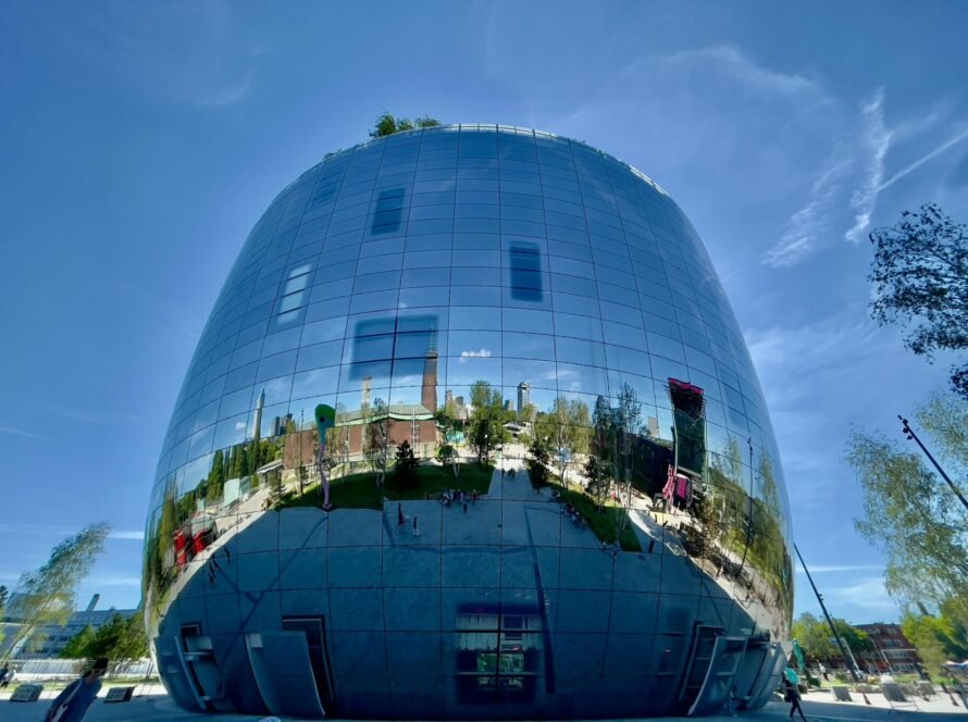8CLICKS| a large round building with a reflection of a city