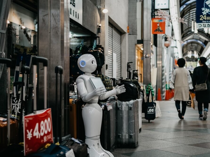 8CLICKS| a robot holding a tablet
