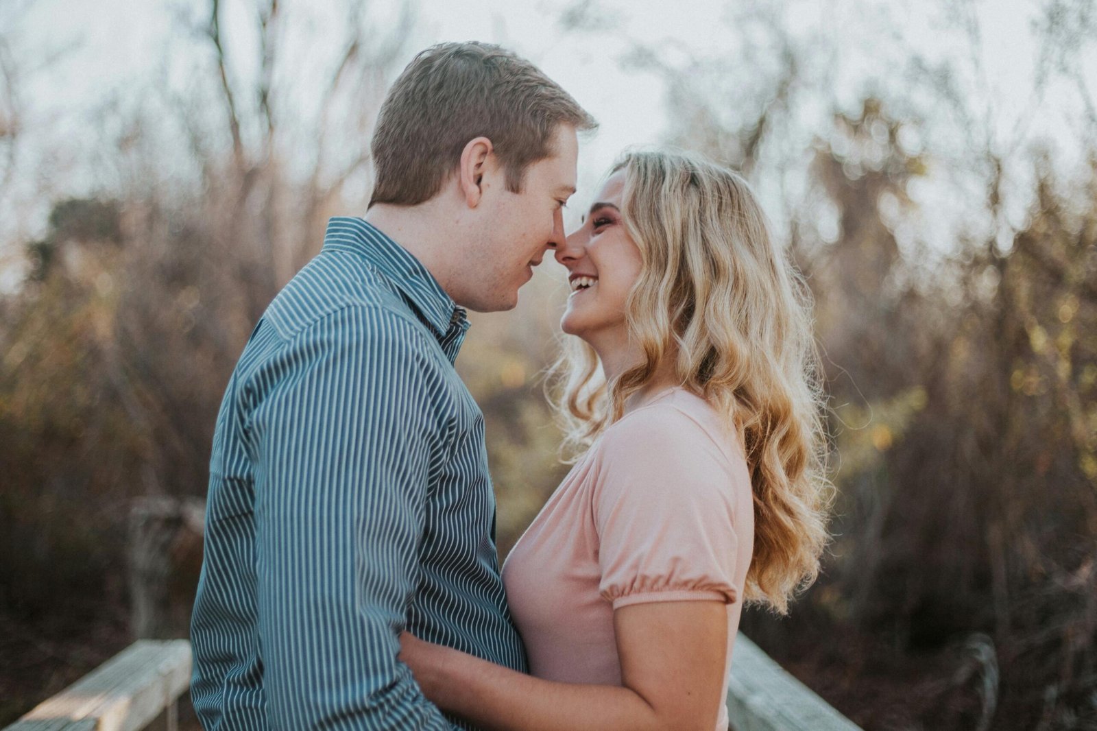 a man and woman smiling and touching noses