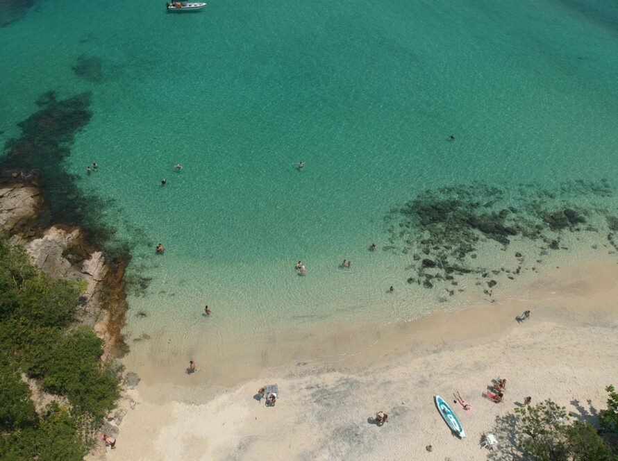a beach with people swimming in the water