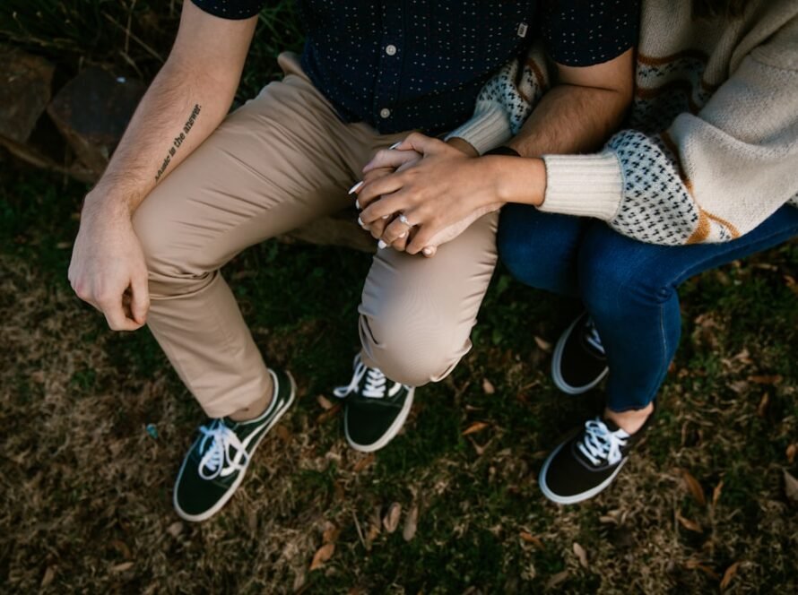 a man and woman sitting on grass