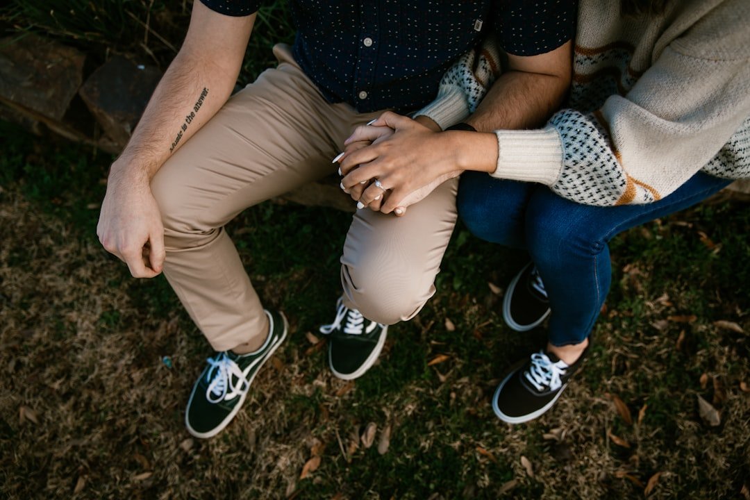 a man and woman sitting on grass