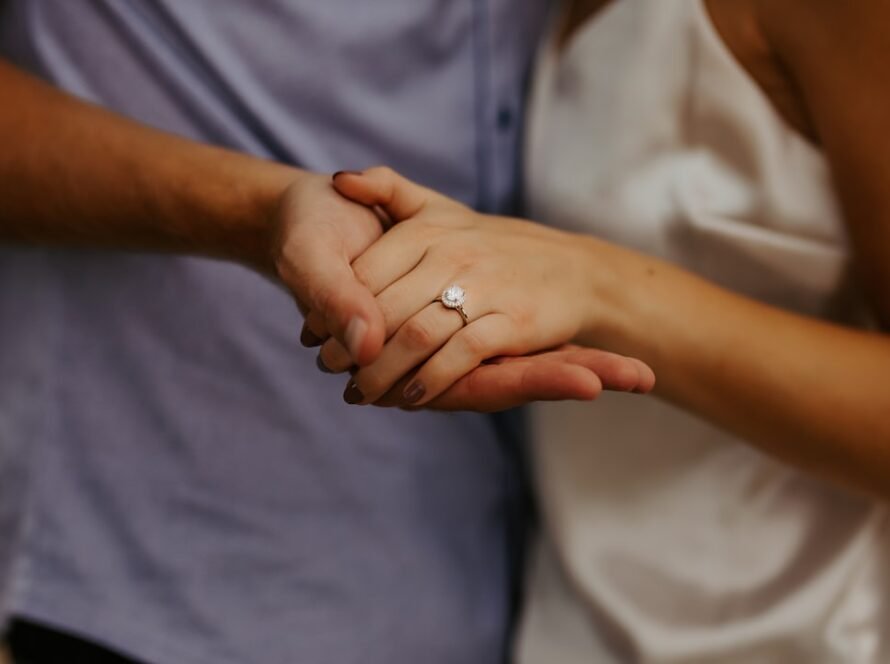 a close up of a man and woman holding hands
