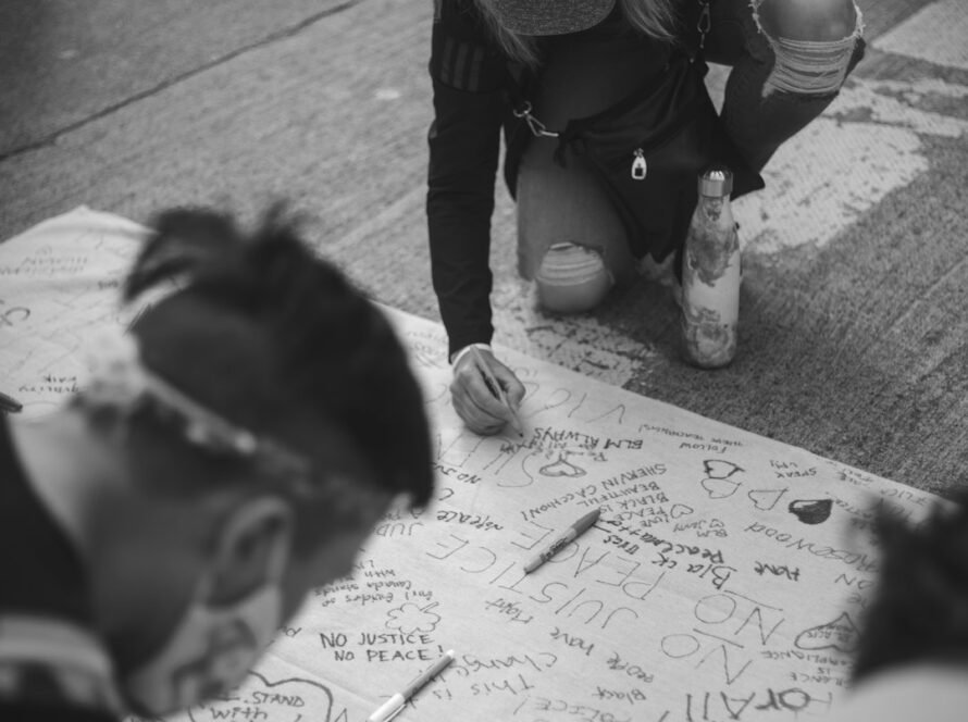 Person writing on protest sign.